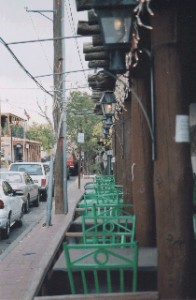 Green chairs at a streetside cafe