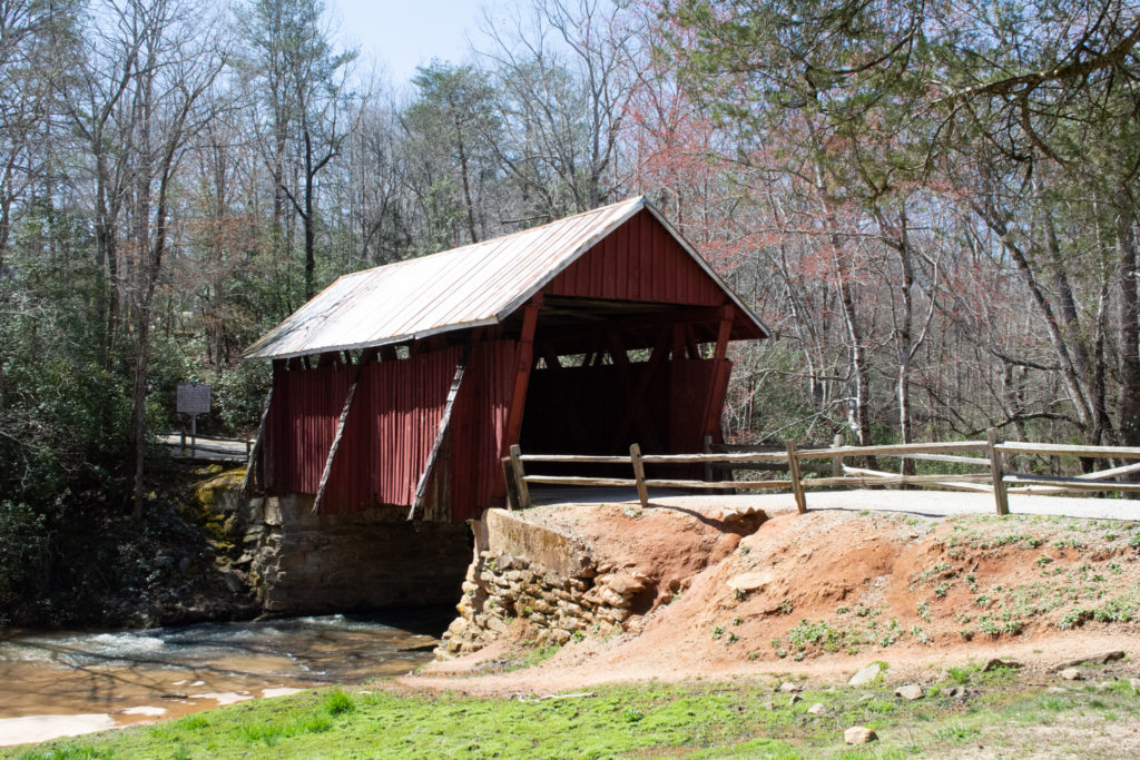 View of a road leading to an old red covered bridge