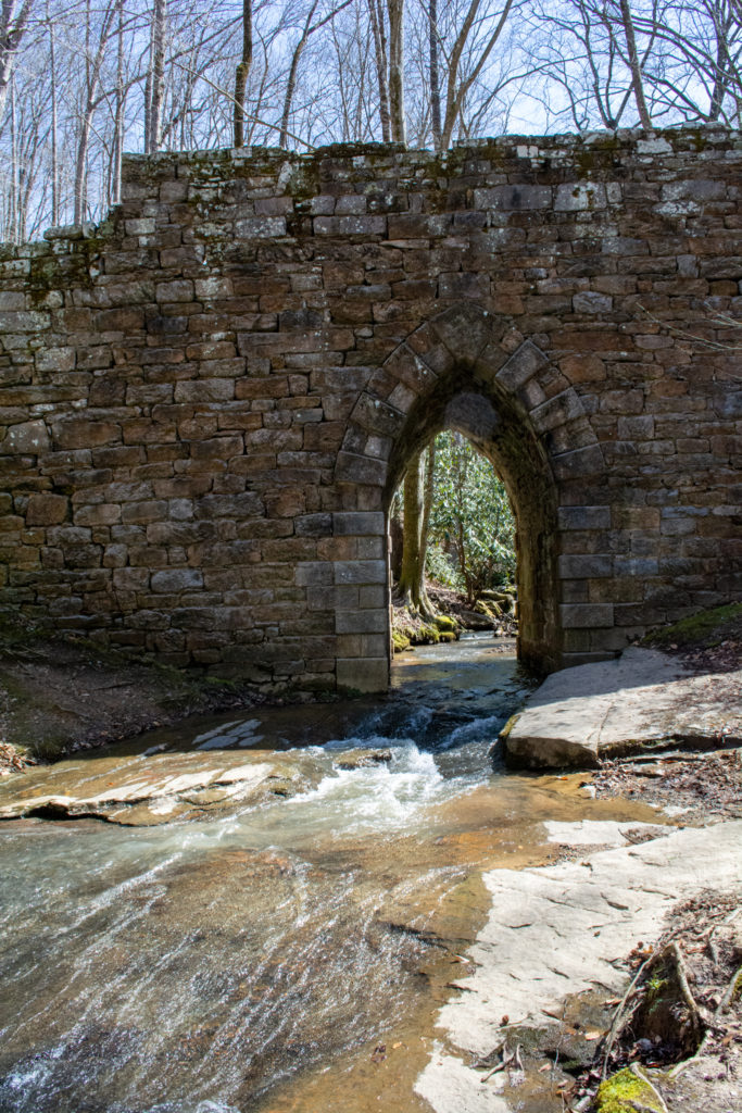 View of the river flowing beneath an old stone bridge