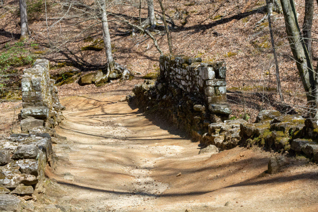 View of the road across an old stone bridge